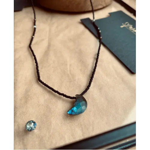 Delicate necklace with black pearls and a faceted half-moon gemstone
